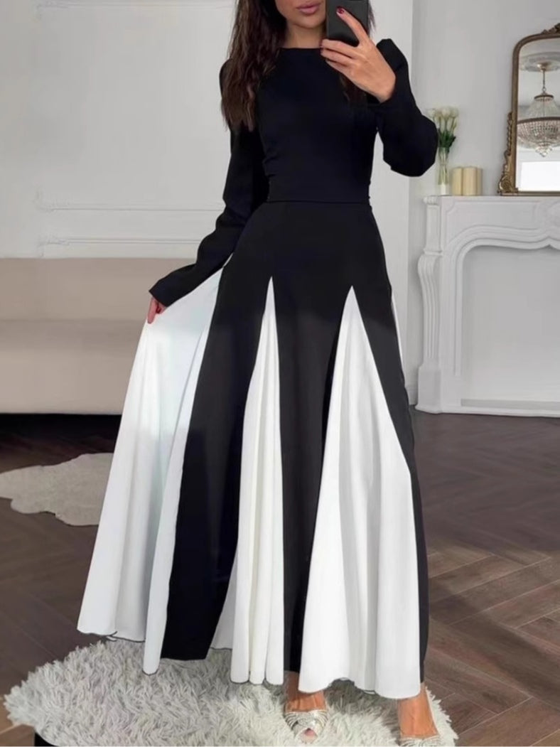 Elegant black and white dress with a round collar, cinched waist, and long sleeves