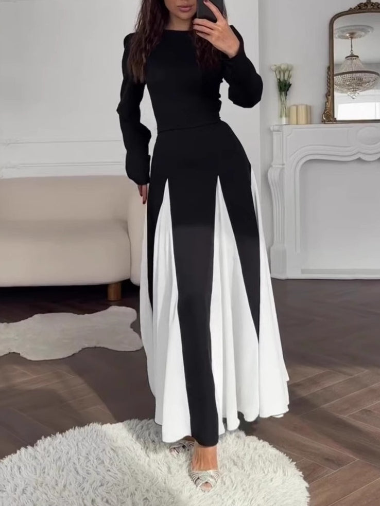Elegant black and white dress with a round collar, cinched waist, and long sleeves