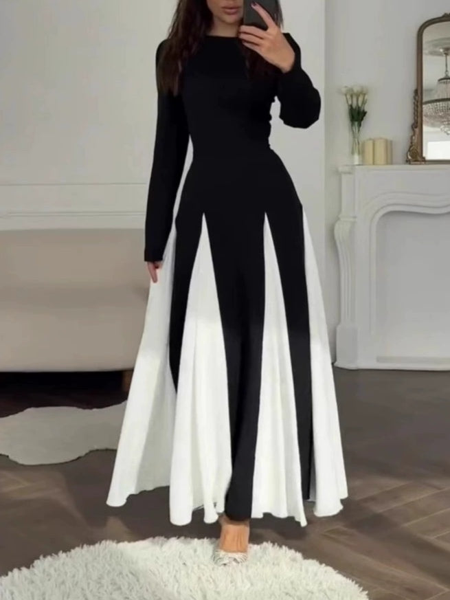 Elegant black and white dress with a round collar, cinched waist, and long sleeves